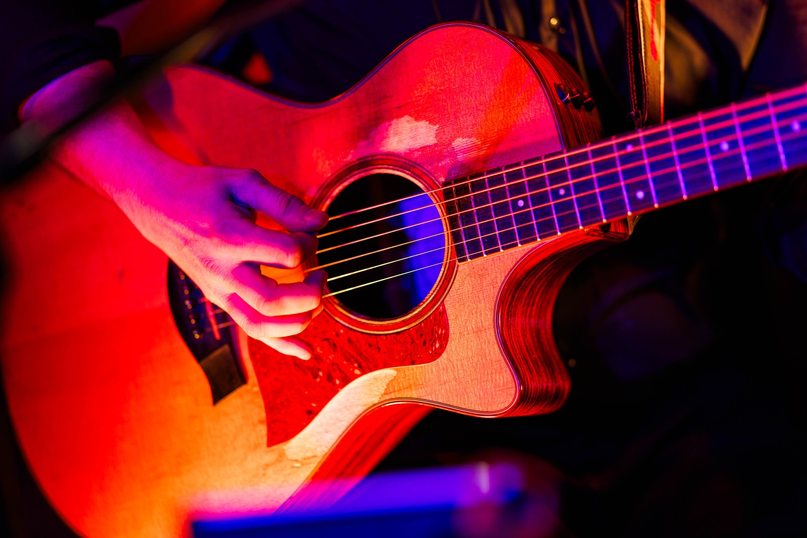 Guitare acoustique en concert au Rambler sous les lumières rouges et violettes