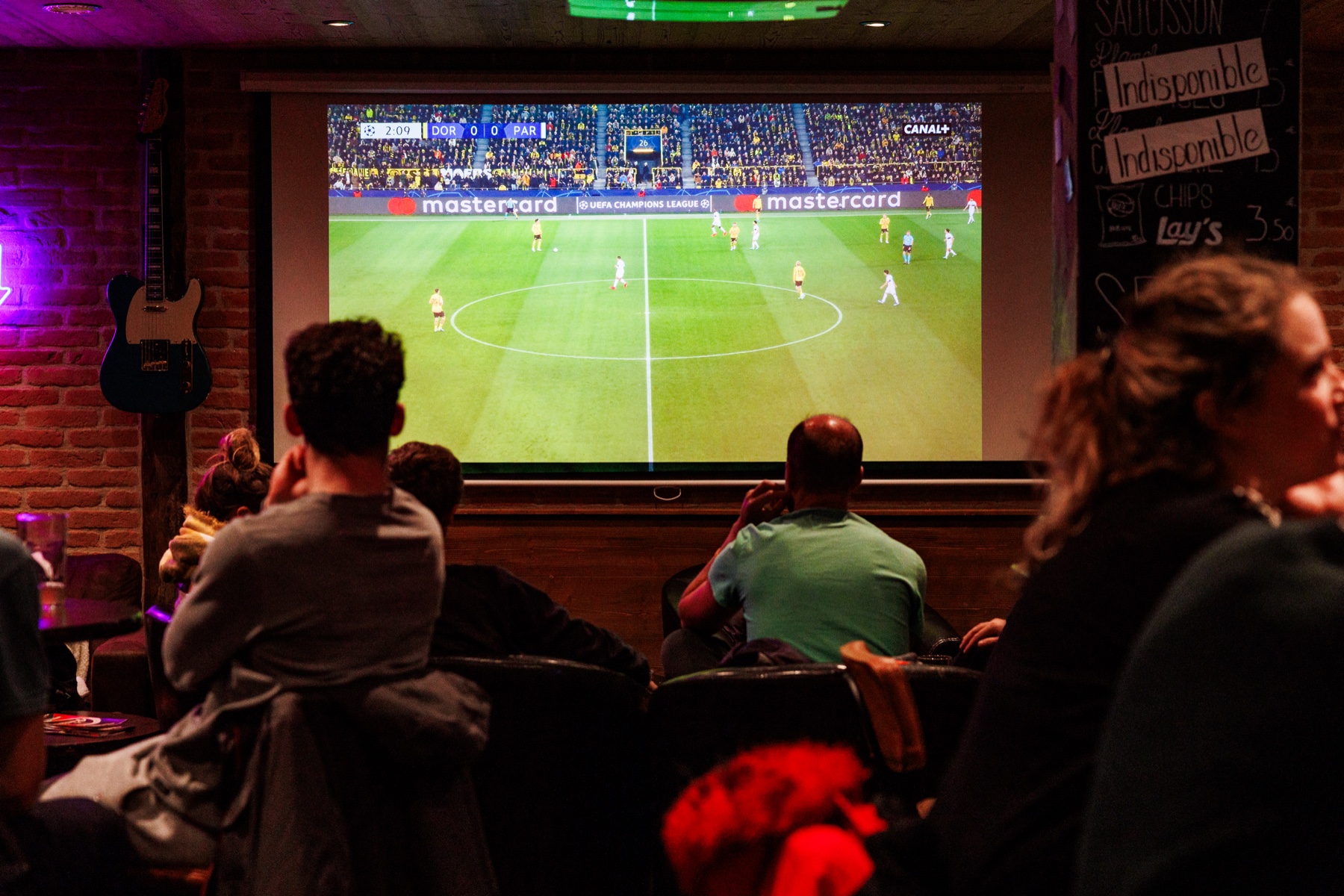 Public regardant un match de Ligue des champions sur l’écran géant du Rambler